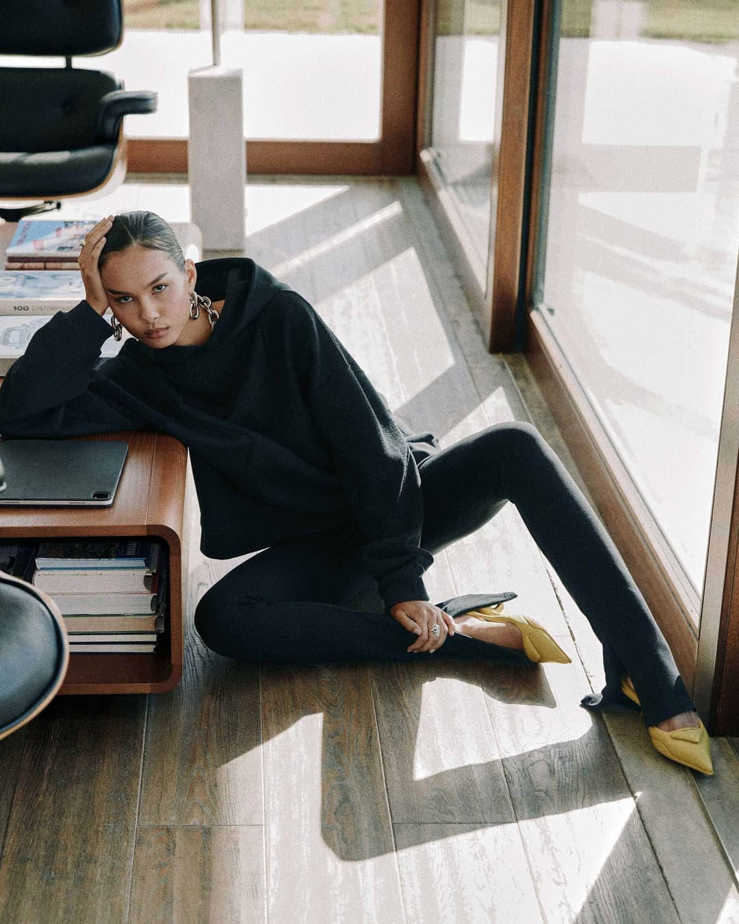 photo of female model sitting on the floor and wearing a hoodie